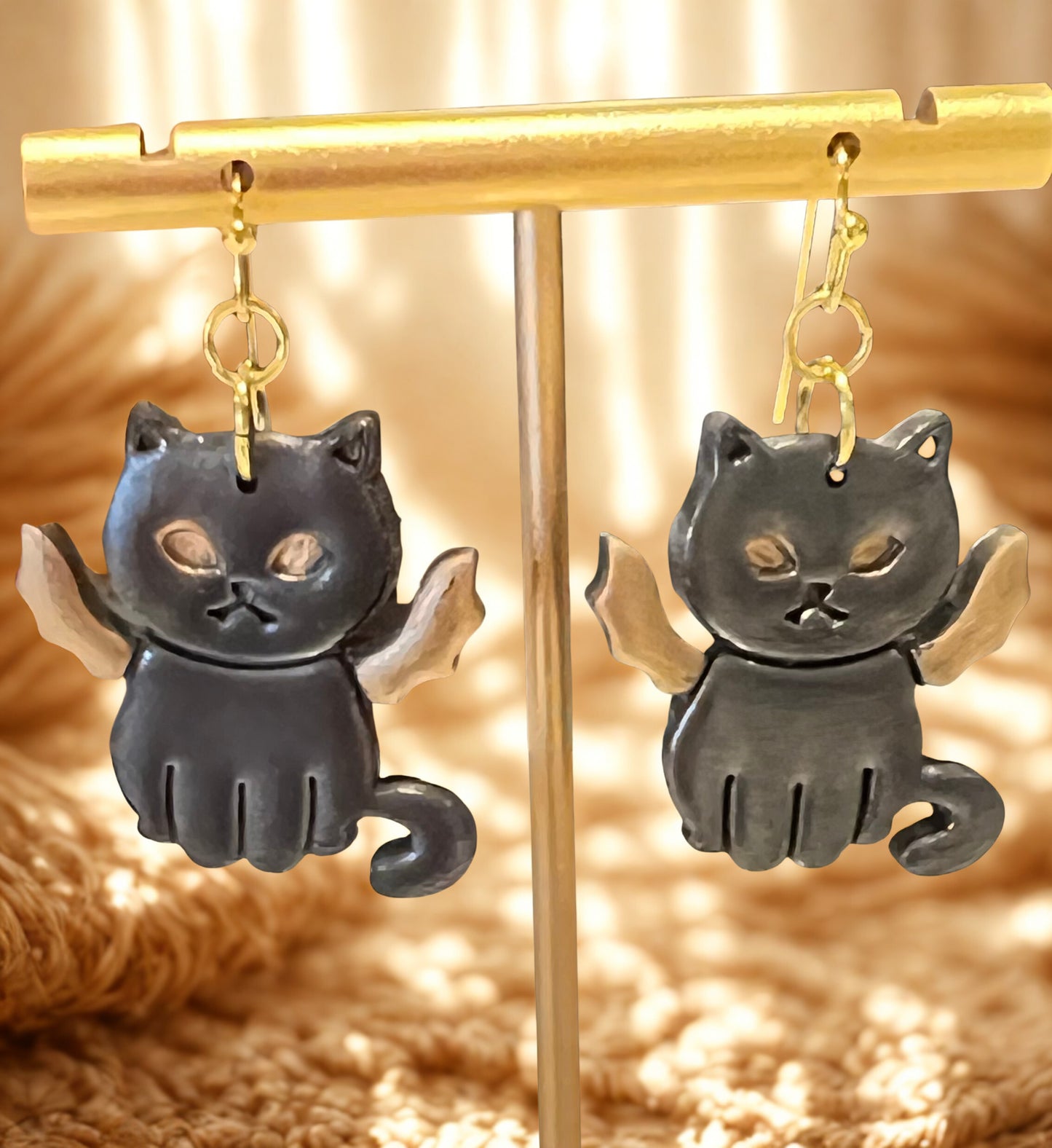 Halloween earrings of a black cat with gold bat wings