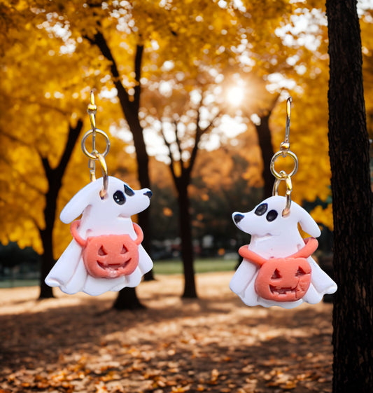 Dog Ghost with a jack-o’-lantern around its neck dangling clay earrings.
